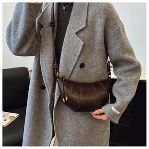 Detailed view of deep brown vintage croissant bag with knotted leather strap and oil wax finish