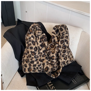 Detail of soft leopard print faux fur tote bag with plush texture on a stylish sofa