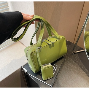 Detail view of avocado green rectangle handbag with glossy finish and matching mini pouch