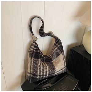 Macro detail of plaid tweed hobo bag with unique knotted shoulder strap design