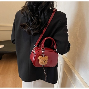Détail du sac bowling en cuir verni rouge avec pendentif ours et double fermeture éclair