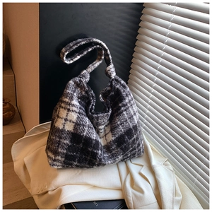 Detail of soft black and white plaid plush tote bag with thick wool-like fabric texture