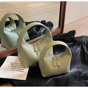 Minimalist light green handbag set with circular handles and smooth matte finish detail