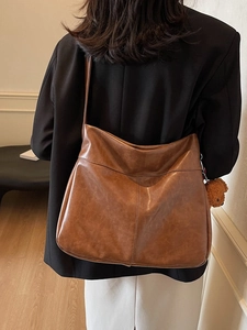 Brown large capacity vintage tote bag for women with cute bear charm shown on model