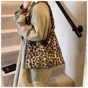 Close-up of leopard print plush tote bag with soft faux fur texture on a shoulder strap