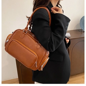 Brown faux leather Boston bag featuring large front zipper pockets and silver hardware
