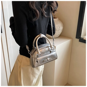 Detail of silver metallic handbag with bow accent worn by model for fashion styling