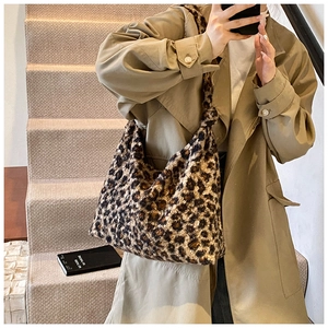 Model wearing a large leopard print plush tote bag with a warm autumn trench coat