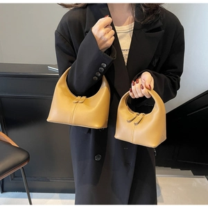 Detail of mustard yellow leather handbags in large and mini sizes with sleek zippers