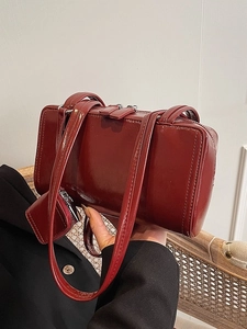 Vintage burgundy underarm bag with polished leather texture and matching coin purse