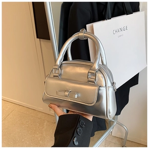 Detail of silver metallic Boston handbag with bow pocket and sleek leather finish