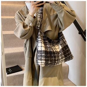 Detail of checkered hobo bag with thick plush fabric and stylish knotted shoulder strap