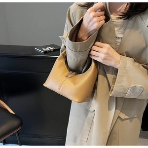 Detail of light brown crescent handbag with smooth leather texture and side stitching