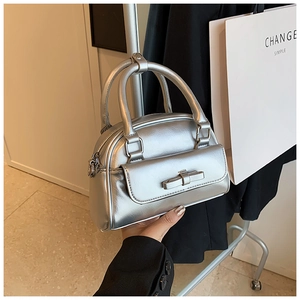 Close-up of metallic silver mini Boston bag with chic bow detail and magnetic pocket