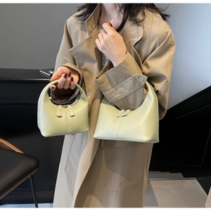 Detail of mint green handbag set with vertical stitching and dual metal zippers