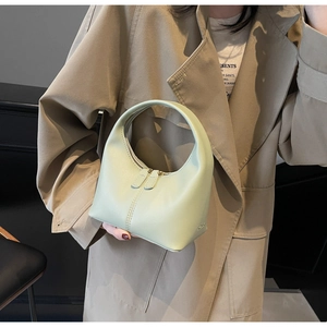 Detail of light green hobo handbag with dual zippers and high-quality leather texture