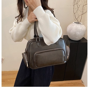 Detail of dark brown vintage Boston bag showing multiple zipper pockets and sleek leather texture