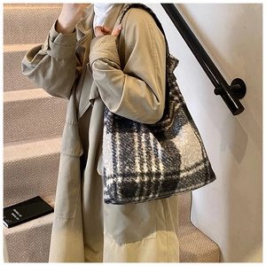 Close-up of winter plaid fuzzy tote bag with textured wool fabric and wide shoulder strap