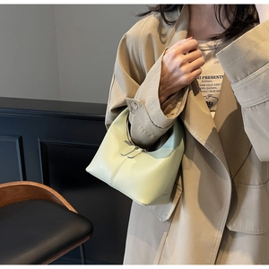 Detail of light green matte leather handbag with dual zippers and vertical stitching
