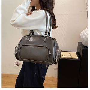 Detailed view of dark brown vintage oil-wax leather handbag with silver zipper pockets