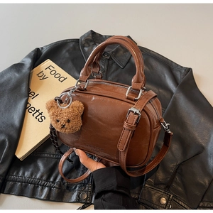 Détails du sac bowling marron vintage avec boucles argentées et pendentif ourson
