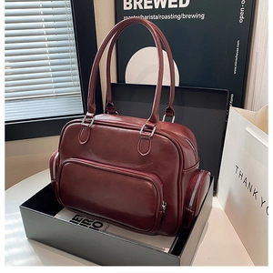 Detailed view of dark red leather tote bag with multi-pocket design in premium gift box
