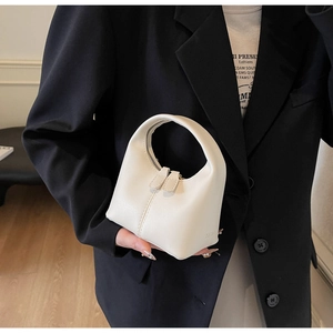 Detailed close-up of cream-white mini hobo bag with dual zipper design and smooth leather texture