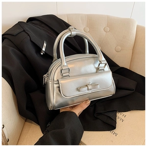 Detailed view of a silver Boston bag with a metallic finish and chic bow decoration