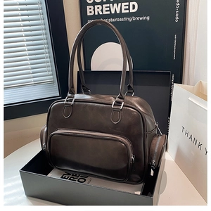 Detailed view of dark brown tote bag with multi-pocket design and silver hardware zippers