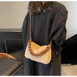 Détail d'un sac bandoulière matelassé en peluche kaki avec bandoulière en chaîne tressée