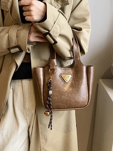 Vintage dark brown leather bucket bag with metal triangle logo and woven rope knot charm