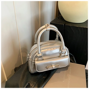 Detailed view of silver Boston bag with metallic finish and bow decorative pocket