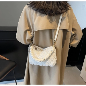 Gros plan du sac oreiller en peluche blanche avec fausse fourrure matelassée et anse tressée