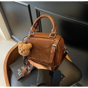 Gros plan du sac à main marron vintage en similicuir huilé avec porte-clé ours