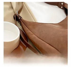 Detail of metal rivets and stitching on a dark brown PU leather hobo shoulder bag