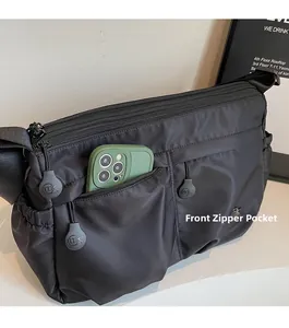Détail du sac en nylon noir montrant la poche zippée pour les grands smartphones