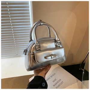Close-up of silver Boston bag with metallic finish and cute bow detail on front pocket