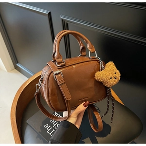 Détail du sac bowling vintage caramel en cuir brillant avec pendentif ourson
