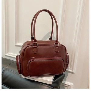 Detail view of large burgundy vintage handbag with multi-pocket design and silver zippers