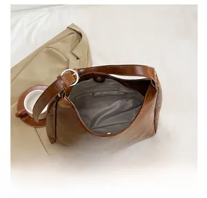 Detailed view of brown leather tote bag interior with magnetic closure and inner zip pocket