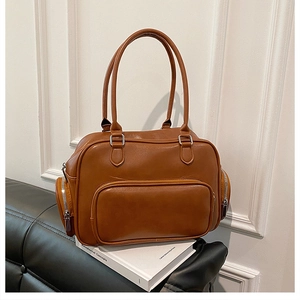 Detailed close-up of a vintage camel faux leather handbag with silver zipper pockets
