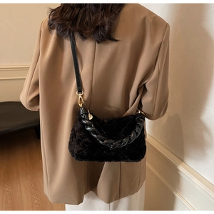 Détail d'un sac bandoulière en fausse fourrure matelassée noire avec anse tressée