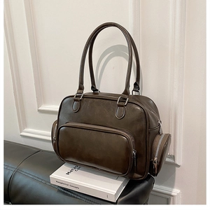 Close-up of vintage dark brown faux leather shoulder bag with multiple functional zippers