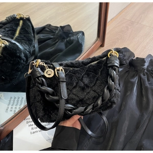 Gros plan détaillé d'un sac à main matelassé en fausse fourrure noire avec anse tressée