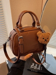 Sac à main rétro en cuir marron avec poignées et un charmant petit ours en peluche