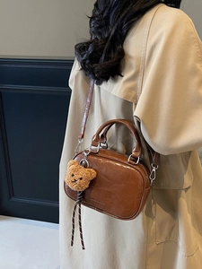 Sac bowling marron vintage avec breloque ours et bandoulière sur mannequin