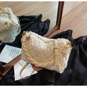 Gros plan d'un sac en peluche blanc avec matelassage et poignée tressée
