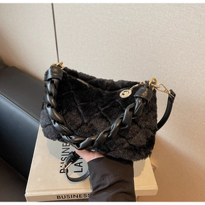 Détail du sac polochon en fausse fourrure noire matelassée avec poignée tressée