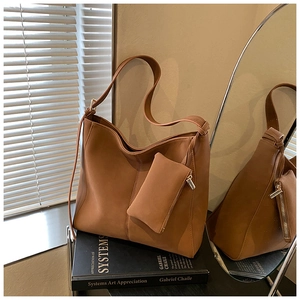 Close-up of vintage brown tote bag with matte finish and matching mini accessory pouch