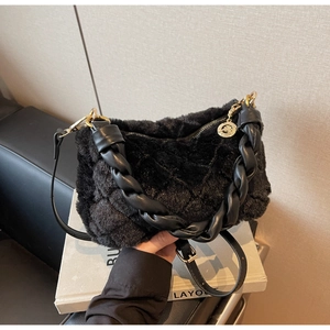 Détail du sac bandoulière matelassé en fausse fourrure noire avec boucle dorée
